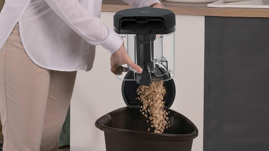 Podlahový vysávač Hoover HP210P 011 čierny/sivý osoba sype nečistoty z nádoby na prach do koša