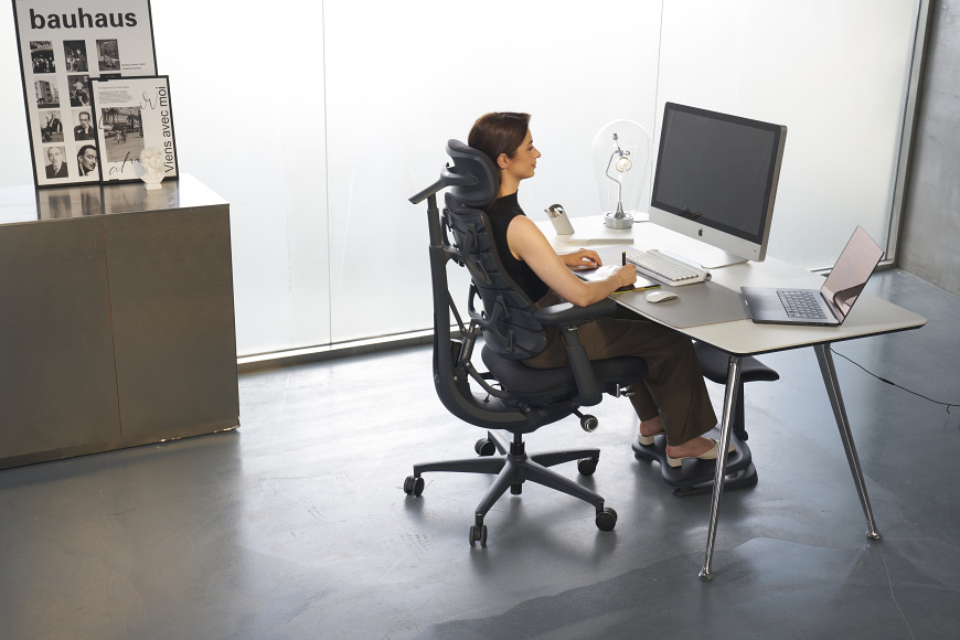 Ergonomická stolička LiberNovo Omni, 48 cm čierna Žena sediaca na ergonomickej stoličke pri pracovnom stole