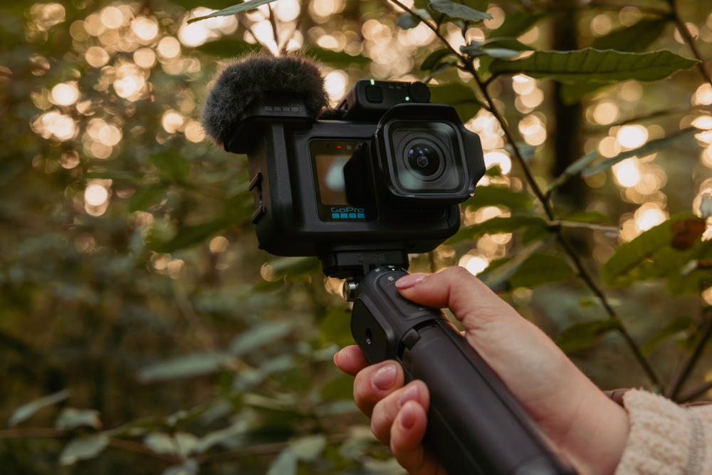 Outdoorová kamera GoPro MISSION 1 PRO Creator Edition čierna Kamera MISSION 1 PRO s mikrofónom v ruke pri natáčaní v lese