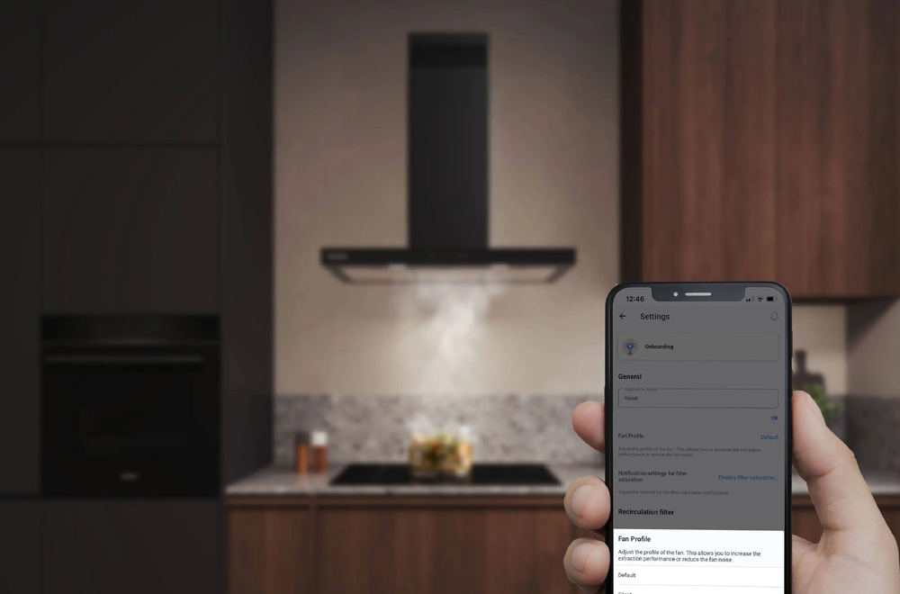 Náhľad na mobilný telefón s aplikáciou Home Connect, v pozadí varná doska a odsávač pár Siemens