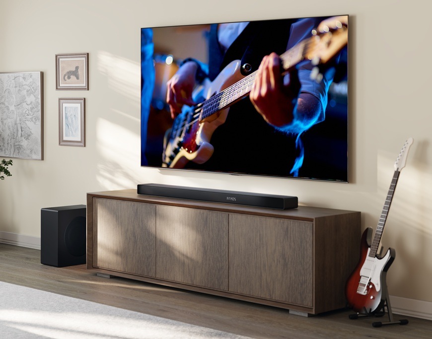 Soundbar Hisense AX3120Q čierny Soundbar Hisense AX3120Q je umiestnený v modernej domácnosti pod televízorom Hisense. V televízii hrá muž na gitaru.