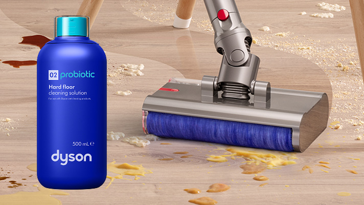 Tyčový vysávač Dyson V12s Detect Slim Submarine + sada pre detailné upratovanie strieborný Vysávač V12s Detect Slim Submarine vedľa probiotického čistiaceho prípravku