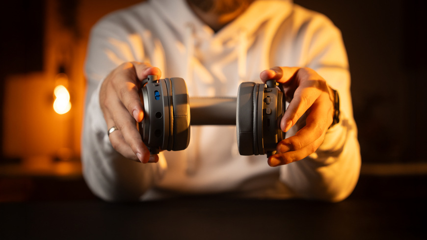 Headset ENDORFY VIRO Wireless Alt Grey sivý Detail ovládacích prvkov a konektorov headsetu ENDORFY VIRO Wireless Alt Grey pri držaní v rukách