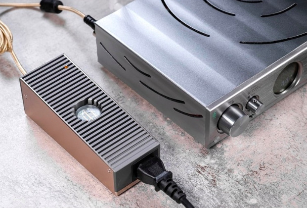 Sieťový adaptér SilentPower iPower Elite 12V sivý Napájací adaptér iFi SilentPower iPower Elite 12V pri zapojení k audio technike doma na stole
