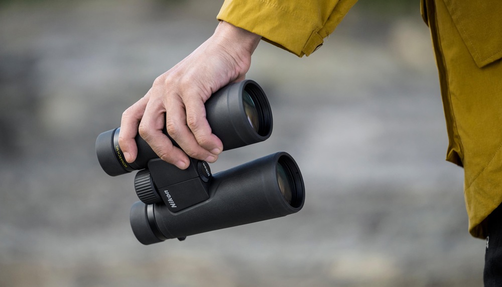 Ďalekohľad Nikon Monarch M5 10×50 čierny Ľahký a kompaktný ďalekohľad Nikon Monarch M5 10×50 držaný v ruke pri pobyte v prírode