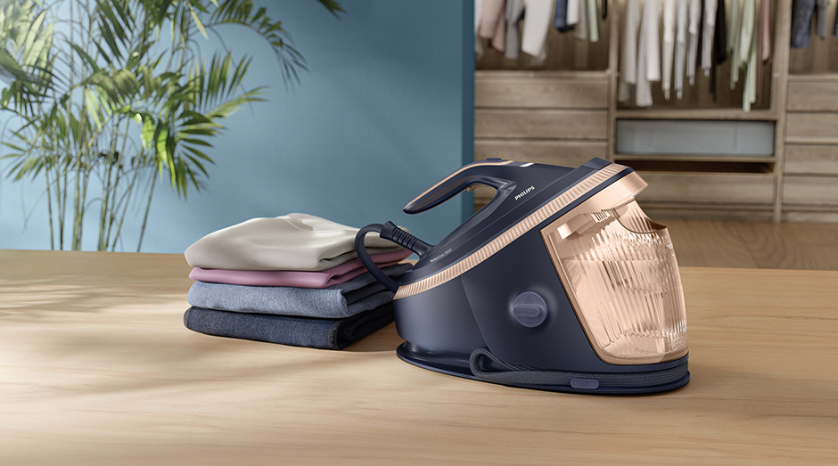 Žehliaci systém Philips 7300 Series PSG7300/20 fialový Žehliaci systém Philips PSG7300/20 7300 Series vedľa vyžehlenej bielizne