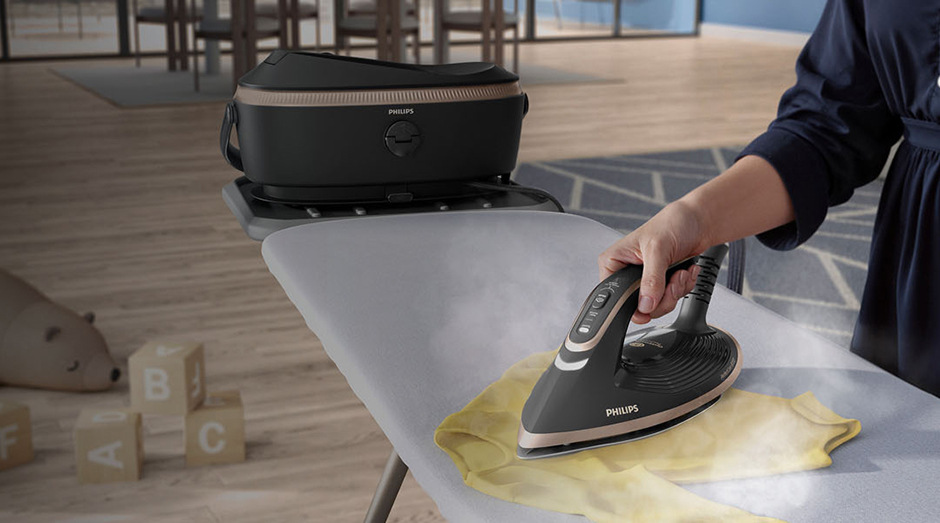 Žehliaci systém Philips 8000 Series PSG8200/80 sivý Muž žehliaci so žehliacim systémom Philips PSG8200/80 8000 Series detské oblečenie v obývacej izbe