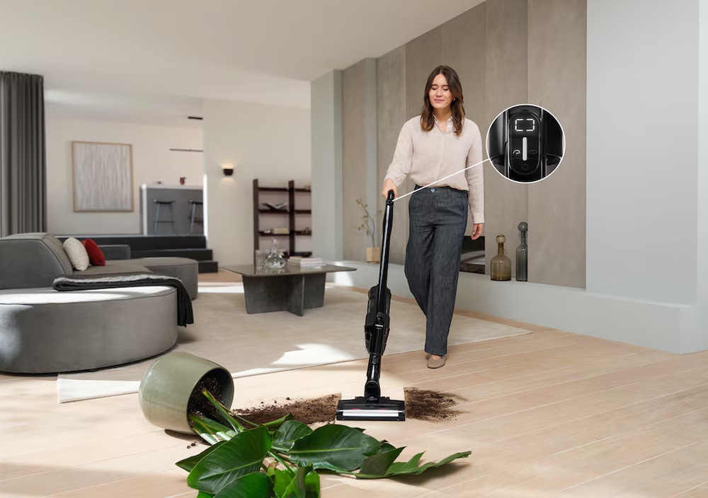 Tyčový vysávač Miele Triflex HX3 Hardfloor Casa sivá Žena vysáva hlinu od spadnutého kvetináča s vysávačom Miele Triflex HX3 s režimom Boost