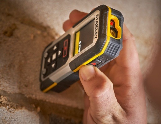 Laserový diaľkomer Stanley FatMax FMHT77050-XJ Laserový diaľkomer Stanley priložený k stene pri meraní v rohov miestnosti.