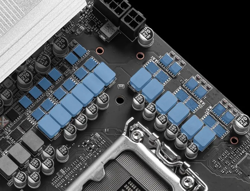 Základná doska MSI PRO B860-P Detail počítačovej základnej dosky s päticou pre procesor obklopenou radmi kondenzátorov a modrými chladičmi.