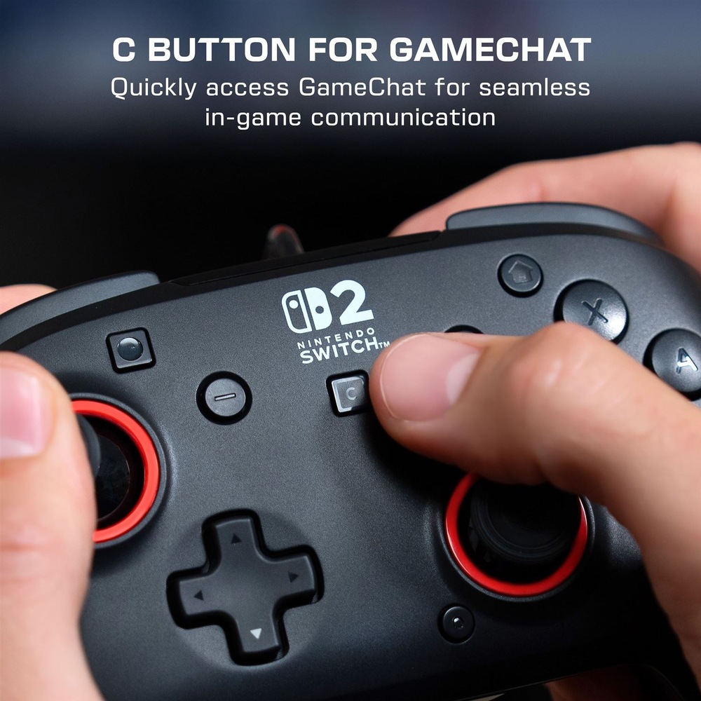 Gamepad Turtle Beach Rematch Wired, NS2 čierny Na obrázku je detail čierneho gamepadu Turtle Beach Rematch Wired držaného v rukách. Uprostred je biele logo Nintendo Switch 2 a prst práve stláča tlačidlo C pre rýchle otvorenie funkcie GameChat. Vidieť sú aj analógové páčky s červenými krúžkami, smerový kríž a hlavné ovládacie tlačidlá. Horný text upozorňuje na ľahký prístup k hernej komunikácii.