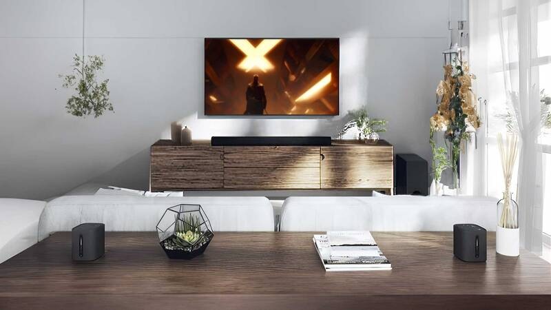 Soundbar Yamaha True X Surround 50A (set) čierny soundbar yamaha true x surround 50a umiestnený pod televíziou v modernej obývacej izbe s bezdrôtovými reproduktormi na stole