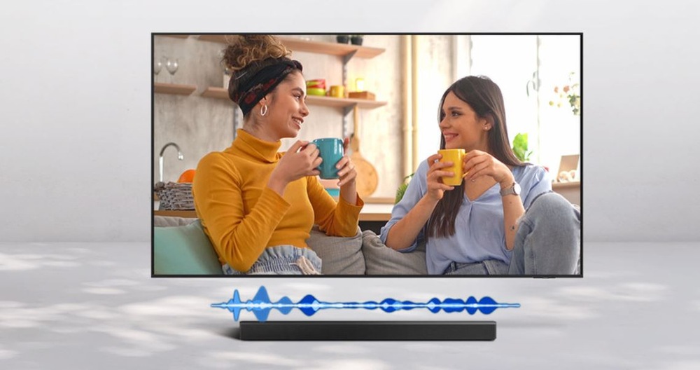 Soundbar Samsung HW-Q930H čierny televízie Samsung, na ktorej je zobrazené dialóg dvoch žien. Pod TV je soundbar. Vďaka režimu Active Voice Amplifier sa zvýši hlasitosť reči, aby lepšie vynikla