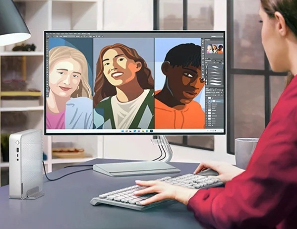 PC mini Lenovo IdeaCentre Mini 01IRH10R sivý Žena vytvárajúca grafiku má vedľa monitora postavený počítač Lenovo IdeaCentre Mini s vertikálnym stojanom