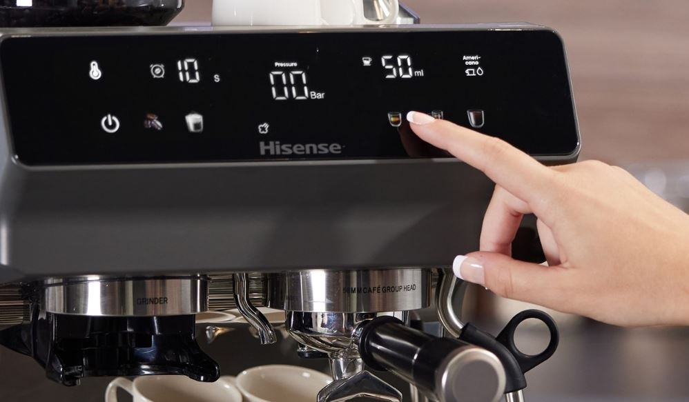 Espresso Hisense HSACM20LP antracitová farba ženská ruka ovláda kávovar Hisense HSACM20LP pomocou jedného prsta. Detail na ovládací panel