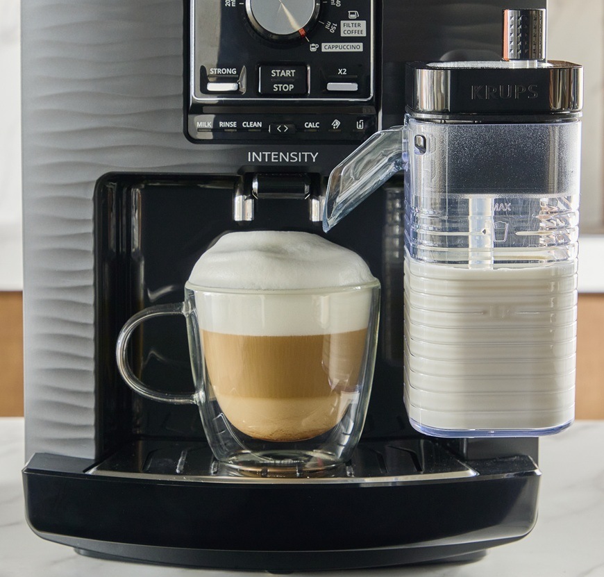 Automatický kávovar Krups EA5028E0 Intensity Up Milk čierny Detailný záber na spodnú časť kávovaru Krups EA5028E0 Intensity Up Milk a šálku s cappuccínom a bohatou penou.