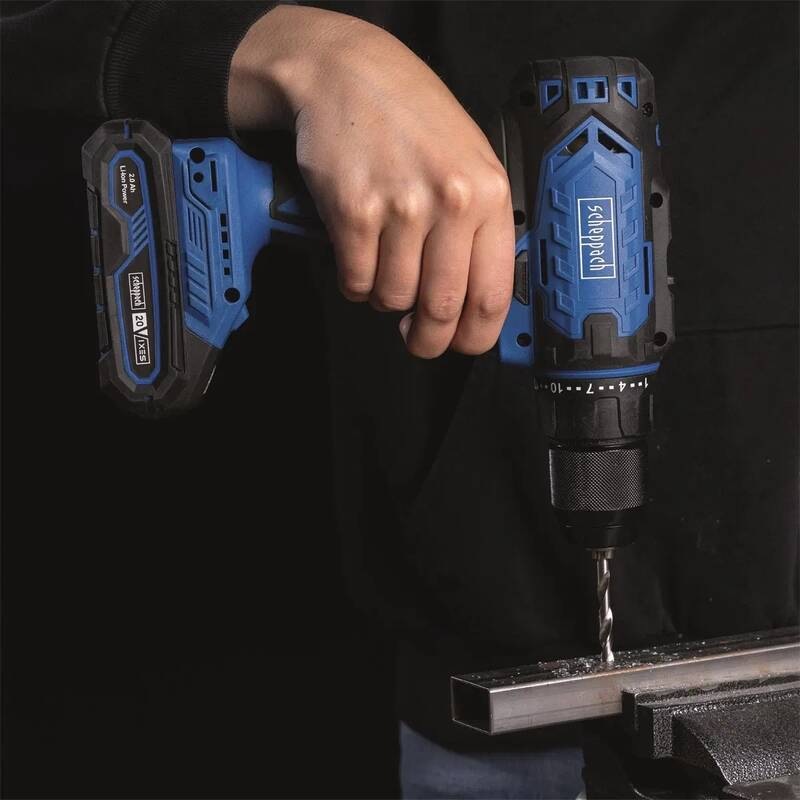 Vŕtací skrutkovač Scheppach C-DD45-X-SET S - 20 V IXES (s baterií) Pohľad na remeselníka pri vŕtaní do kovového profilu aku vŕtačkou Scheppach 20 V IXES, detail na skľučovadlo a piliny.