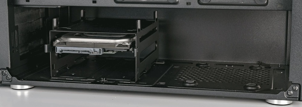 Otvorená skriňa počítača odhaľujúca pevný disk namontovaný vo vnútri kovového držiaka. Pozadie je kovové a povrch je hladký a čistý.