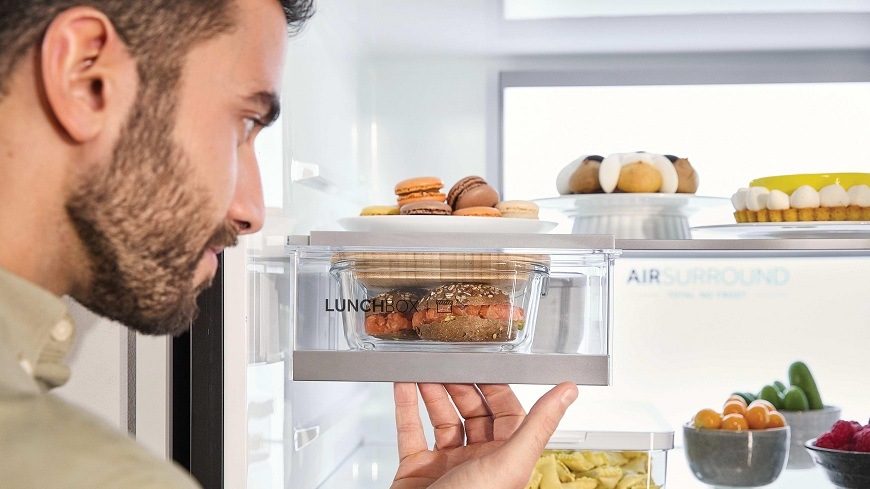 Chladnička s mrazničkou Haier HDR5818DNSS nerez muž drží v ruce zásuvku lunchbox