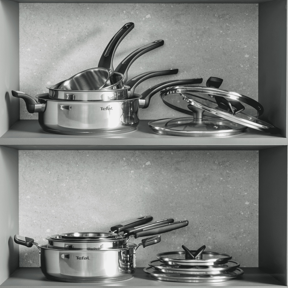 Rajnica Tefal Emotion+ E3282745, 14 cm nerez Rajnice Tefal a pokrievky uložené na poličkách v skrini v kuchyni.