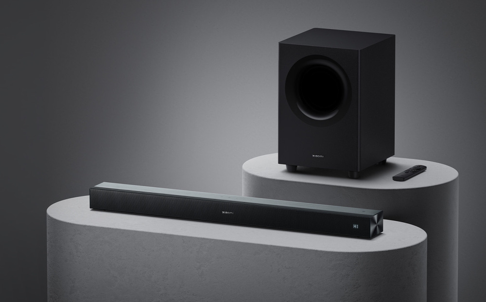 Soundbar Xiaomi PRO 2.1 ch čierny Soundbar Xiaomi PRO 2.1 ch s bezdrôtovým subwooferom umiestnený v modernej izbe pre domáce kino
