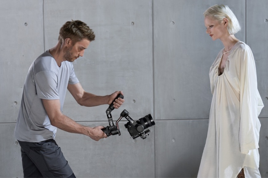 Muž robí záber modelky z nízkeho uhla pomocou držiaka DJI RS 5 Electronic Briefcase Handle