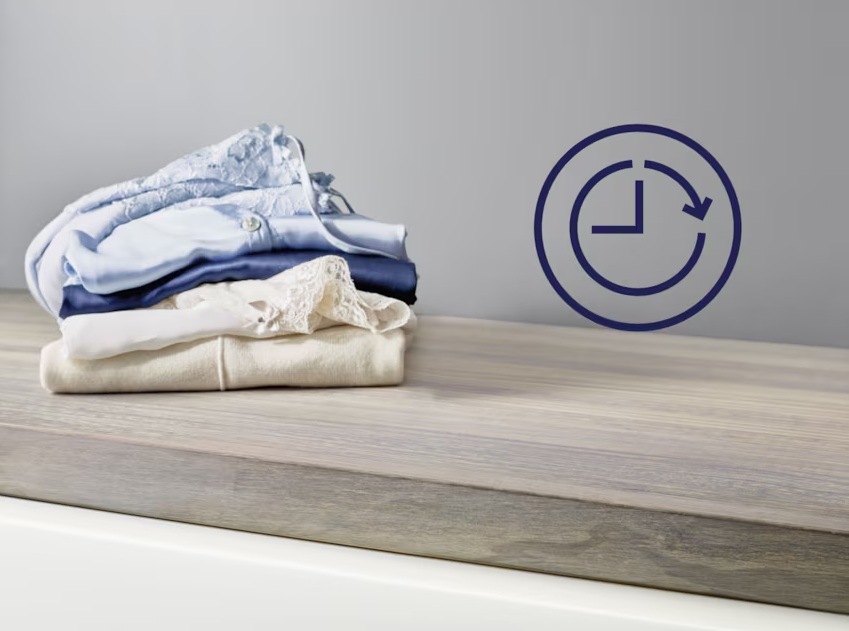 Vľavo kôpka poskladaných tričiek. Vpravo symbol odloženého štartu.