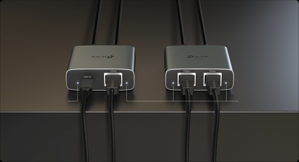 Rozbočovač TP-Link EH210 sivý Dva elegantné kovové sieťové adaptéry s logom TP-Link ležia na tmavom povrchu. Každý adaptér má ethernetové káble zapojené do portov 10 Gb/s, ktoré zaisťujú moderné pripojenie.
