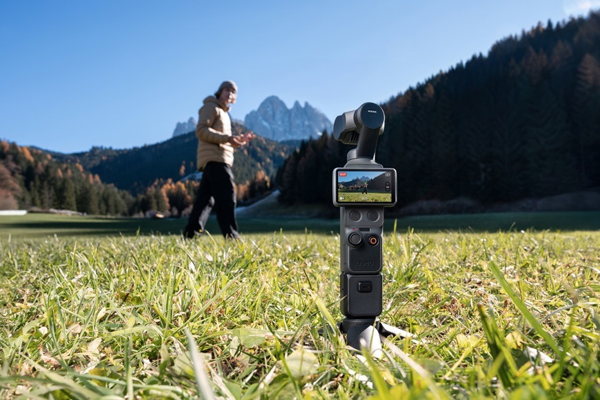 Outdoorová kamera DJI Osmo Pocket 4 Creator Combo čierna Detail obrázku kamery umiestnené v tráve.