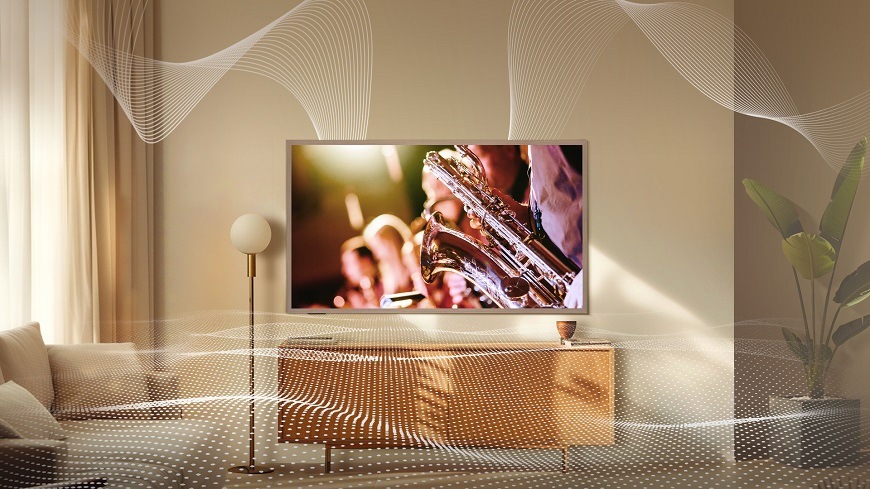 Televízor Hisense 55S7S Televízia Hisense v obývacej izbe. Visí na stene vedľa lampy a premieta sa na nej koncert, detail hudobného nástroja. Okolo TV sú zvukové vlny.
