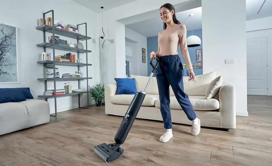 Tyčový vysávač Hoover HW300 011 čierny/strieborný žena používa vysávač Hoover HW300 011 v obývačke