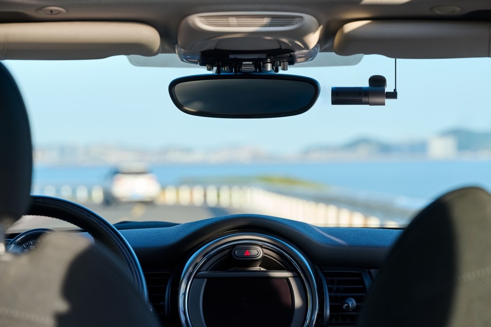 Autokamera 70mai M310 Plus 4K čierna Pohľad z interiéru automobilu na autokameru 70mai M310 Plus 4K pripevnenú v hornej časti čelného skla vedľa spätného zrkadla.