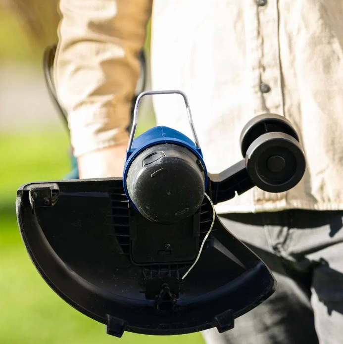 Vyžínač Scheppach C-LT300-X-SET S (s baterií) Detail strunovej hlavy vyžínača s vodiacim kolieskom a ochranným krytom