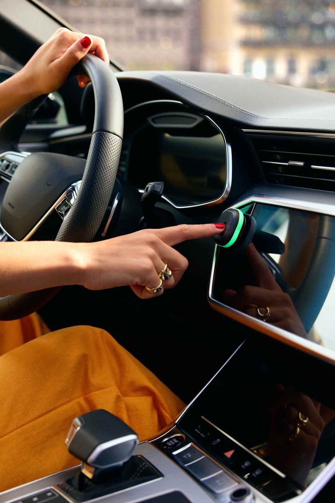 Ruka ukazujúca na zariadenie TomTom v aute