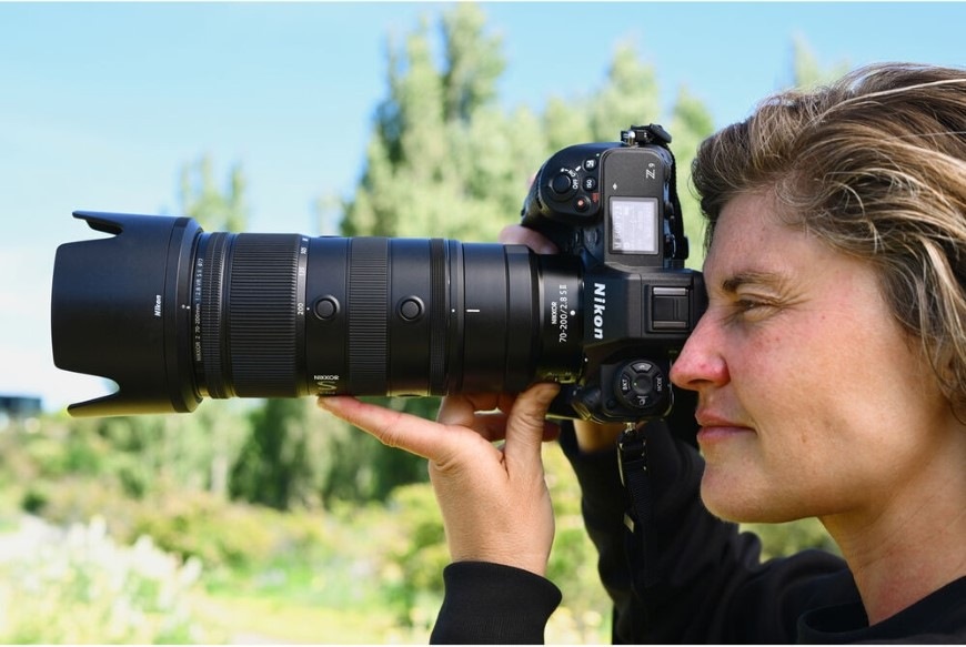 Objektív Nikon NIKKOR Z 70-200 mm f/2.8 VR S II čierny Žena fotografujúca v prírode s fotoaparátom Nikon a teleobjektívom NIKKOR Z 70–200 mm f/2.8 VR S II
