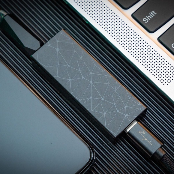 Slúchadlový zosilňovač Cayin RU3 fialový Detail obrázku zosilňovača umiestneného vedľa notebooku.