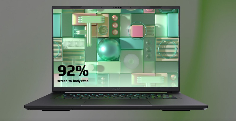Notebook GIGABYTE AERO X16 1WH93CZC64AH čierny/sivý Notebook s abstraktným geometrickým dizajnom, so zelenými a ružovými tvarmi. Text znie „Pomer obrazovky k telu 92 %“.