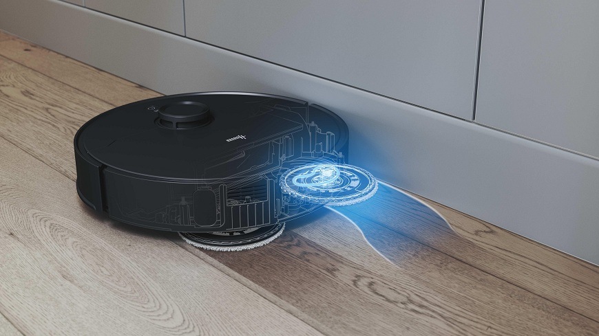 Robotický vysávač Hoover HG870HU 011 mopuje pri okraji nábytku a vysúva jeden mop, aby to vytrel čo najbližšie