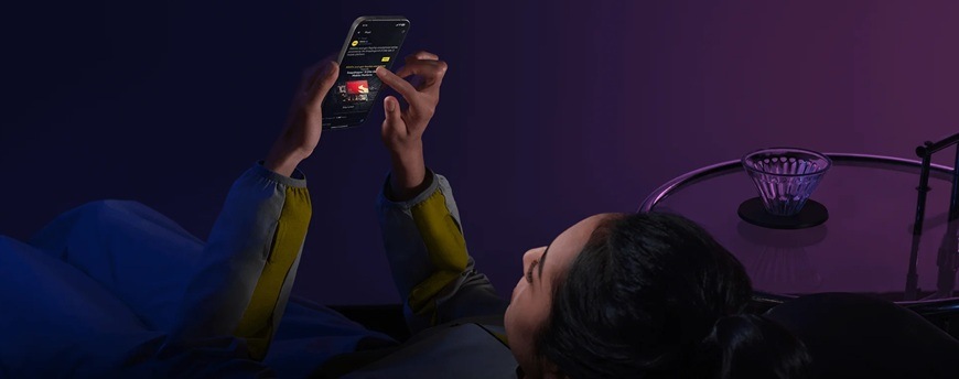 Mobilný telefón Poco F8 Pro 5G 12 GB / 512 GB modrý Dievča sledujúce displej v tmavej miestnosti.