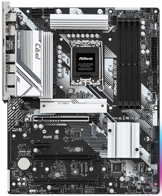 Z horného pohľadu je v ľavej hornej časti zadný I/O panel s portami pre externé zariadenia. Hore uprostred je pätica Intel 1700 a vpravo od nej štyri DDR5 sloty. Na pravom okraji je 24pin napájanie a hore napájanie pre CPU. Uprostred sú PCIe sloty pre grafiku a rozšírenie, blízko sú tri M.2 pozície a na pravej/spodnej časti štyri SATA porty. Dole sú konektory pre predný panel skrine, interné USB, audio, RGB a ventilátory.