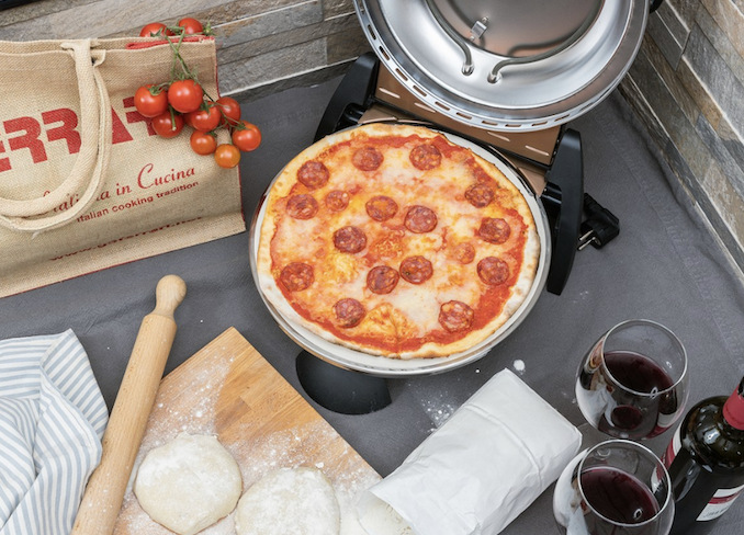Pec na pizzu G3 Ferrari G1000608 DELIZIA bronzová Otvorená pec na pizzu s upečenou pizzou, pripraveným cestom a prestretým stolom