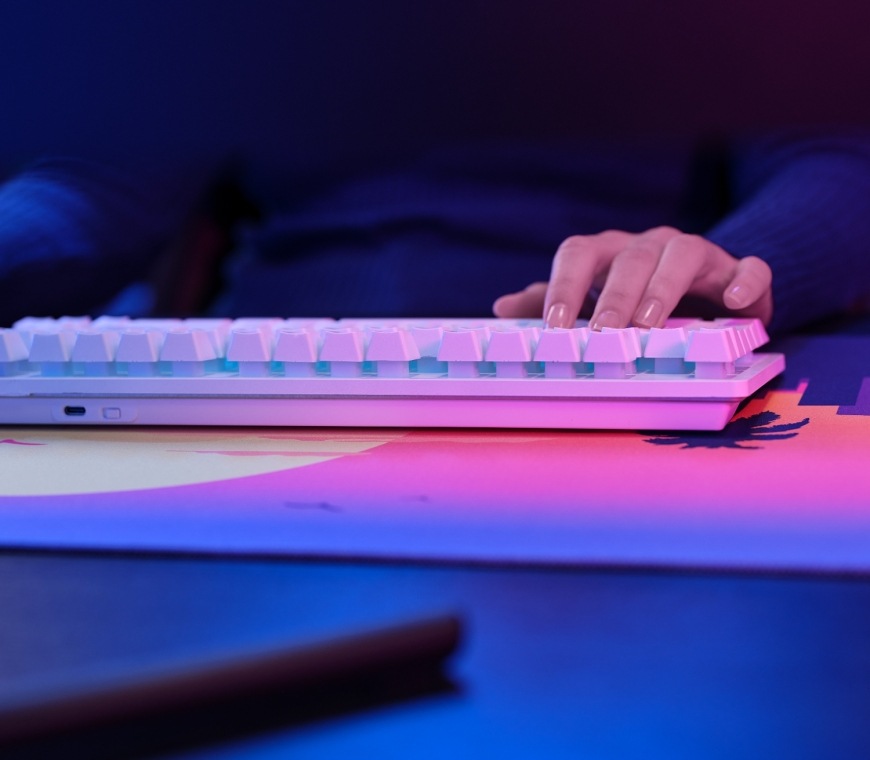 Klávesnica s myšou Trust GXT 882 Wireless - TKL Keyboard, Mouse & XXL Mousepad Miami - CZ/SK biela farba Ruka na klávesnici Trust GXT 882 Miami s RGB podsvietením pri pohľade zboku