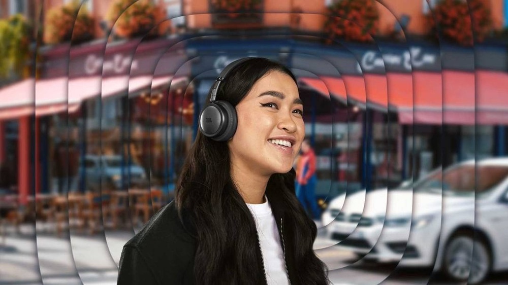 Žena so slúchadlami JBL Live 680NC je obklopená zvukovými vlnami