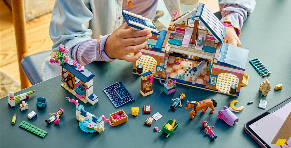Stavebnica LEGO® Friends 42688 Konská stajňa a jazdecká akadémia Pred jazdou deti kone nakŕmia senom a mrkvou, upravia im srsť a pripravia sedlá aj ďalšie jazdecké vybavenie.