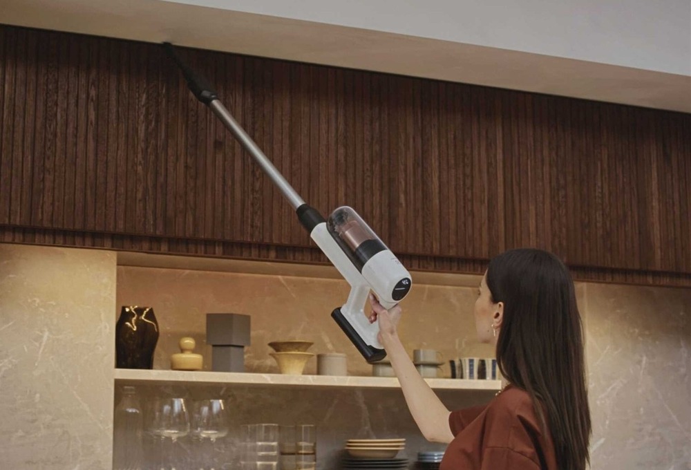 Žena vysáva s vysávačom Electrolux pod stropom.