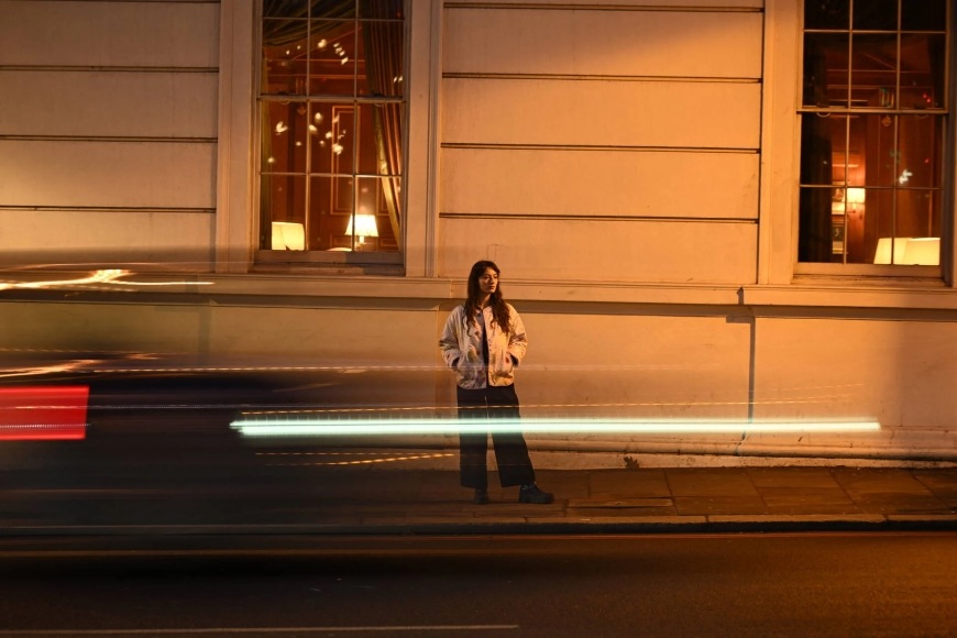 Digitálny fotoaparát Nikon Z 5II + 24-105 mm f/4-7.1 čierny Nočná snímka ženy v meste urobený fotoaparátom Nikon Z 5II je dostatočne jasný a obsahuje minimum šumu