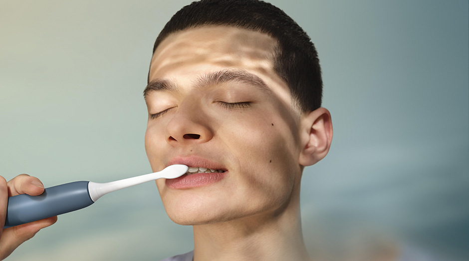 Muž si čistí zuby kefkou sonicare