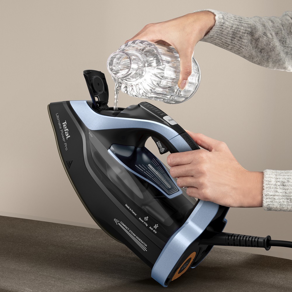 Žehlička Tefal Ultimate Power Pro FV9E53E0 čierna/modrá Žena nalieva vodu do veľkej vodnej nádržky žehličky Tefal FV9E53E0 Ultimate Power Pro