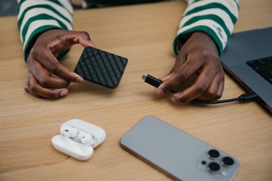 Detail rúk pripájajúcich k notebooku SSD externý disk Verbatim Store 'n' Go Mini Diamond s rýchlym USB-C