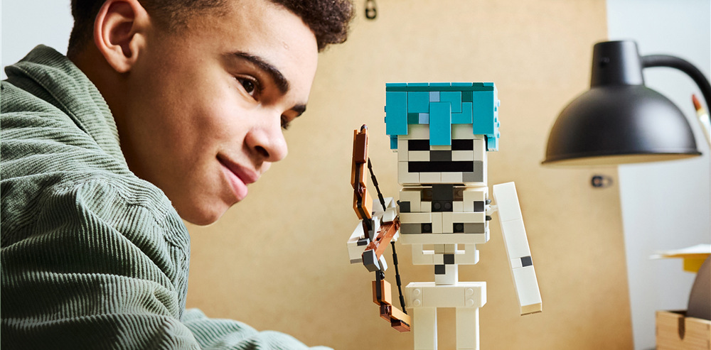 Stavebnica LEGO® Minecraft® 21594 Kostlivec QR kód odomkne diamantovú čiapku kostlivca, ktorú je možné využiť priamo vo videohre Minecraft.